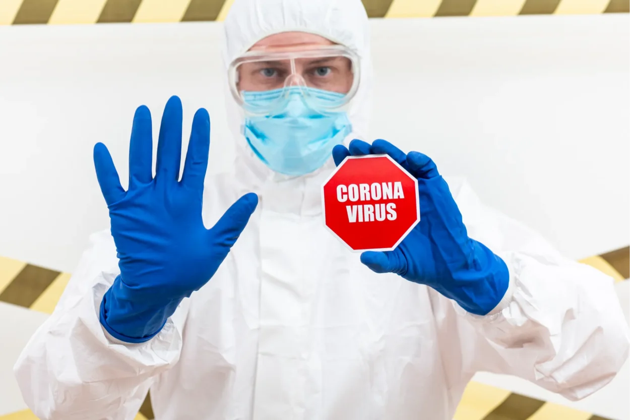  man-hazmat-suit-with-coronavirus-stop-sign 1